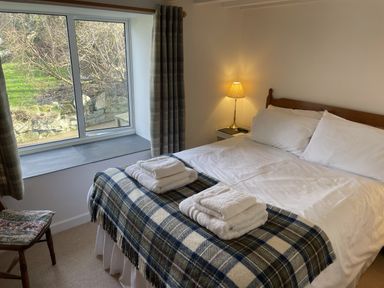 A bedroom with a bed and window at Penllain in Newport, Pembrokeshire
