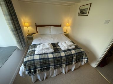 A bedroom with a double bed and towels at Penllain in Newport, Pembrokeshire