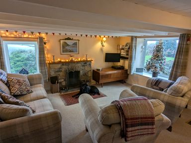 A living room with a fireplace and television at Penllain Newport, Pembrokeshire