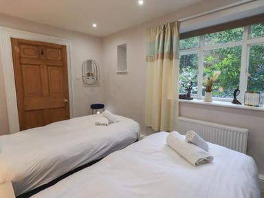 A bedroom with two beds and a window at Red Screes in Ambleside