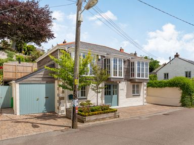 A house with blue doors and windows and a small garden bed in front at Armando in Devoran Cornwall