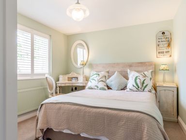 A bedroom with a bed a dressing table with a chair and a bedside cabinet at Armando in Devoran Cornwall