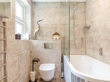 A bathroom with a bathtub shower and a wall-mounted toilet at Armando in Devoran Cornwall