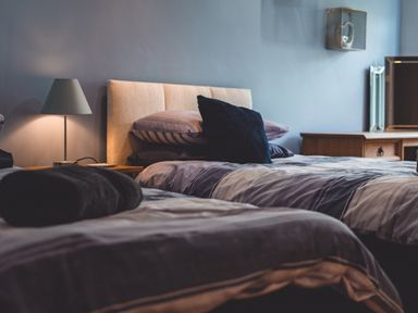 A bedroom with two single beds a bedside table with a lamp and a wooden dresser with a mirror at The Old Post Office in Llandrindod Wells