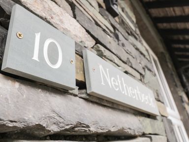 A stone wall with house number 10 and a sign saying Netherbeck in Ambleside