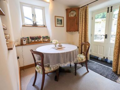 A dining room with a table and chairs at Fellside Cottage in Bowness-On-Windermere