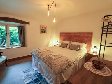 A bedroom with a bed and bedside tables at Fellside Cottage in Bowness-On-Windermere
