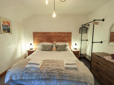 A bedroom with a bed and nightstand at Fellside Cottage Bowness-On-Windermere