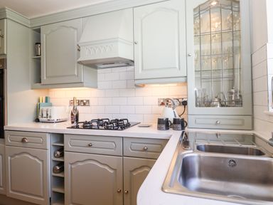 A kitchen with a gas stove sink cabinets toaster and glass cupboard at Pooley Howe in Keswick