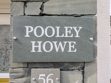 A stone wall with a sign reading POOLEY HOWE and the number 56 at Pooley Howe Keswick