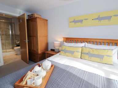A bedroom with a bed and wardrobe at Ocean View Apartment in Colwyn Bay