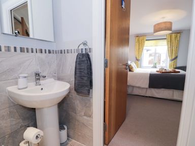 A bathroom with a sink and mirror at Ocean View Apartment in Colwyn Bay