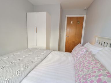 A bedroom with a bed and wardrobe at Ocean View Apartment in Colwyn Bay