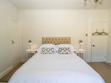 A bedroom with a double bed two bedside tables with lamps and two doors at 23 Daniel Street Bath