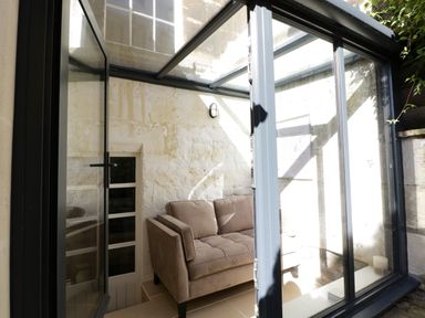 A small enclosed seating area with a sofa and glass walls at 23 Daniel Street in Bath