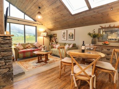 A living room with two sofas a wooden coffee table and a dining table with four chairs at The Badger's Shack in Garnett Bridge Longsleddale Near Kendal