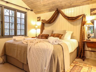 A bedroom with a bed with folded towels and blankets beside a window at The Badger's Shack in Garnett Bridge Longsleddale Near Kendal