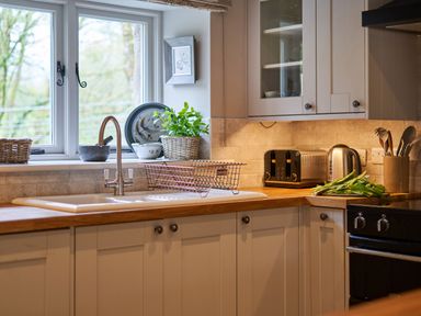 A kitchen with a sink dish rack toaster kettle and utensils at The Old Water Mill in Kendal