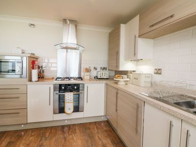 A kitchen with oven microwave toaster bread bin and sink at The Lobster Pot in Westward Ho