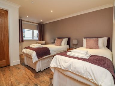 A bedroom with two single beds lamps and a window at The Lobster Pot in Westward Ho