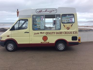 An ice cream van parked by the seaside with ice cream menu on the side at The Lobster Pot in Westward Ho