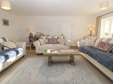 A living room with three sofas and a wooden coffee table at Haul A Gwynt in Criccieth