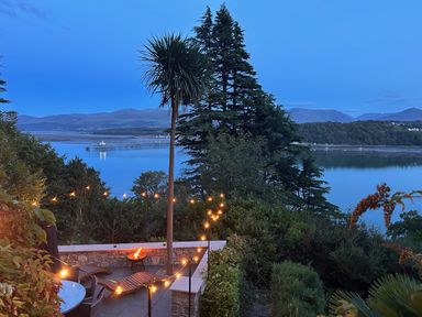 An outdoor area with seating overlooking water at Afallon in Menai Bridge