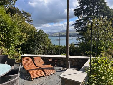 An outdoor area with deck chairs and a view of the water at Afallon Menai Bridge