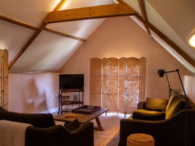 A living room with a television and sofa at Carrows Stable in Morwenstow