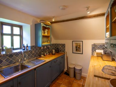 A kitchen with cabinets and sink at Carrows Stable in Morwenstow