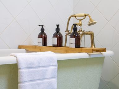 A bathtub with shampoo, conditioner, and bodywash at Carrows Stable Morwenstow