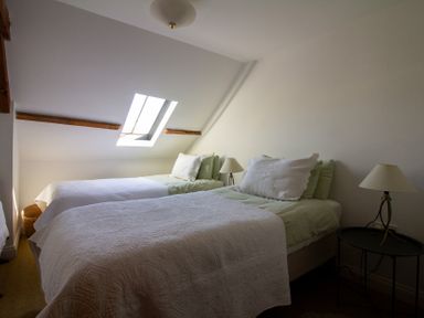 A bedroom with two beds and a window at Carrows Stable Morwenstow