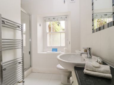 A bathroom with a sink a toilet a shower and a towel rack at Glen Cottage in Troutbeck near Keswick