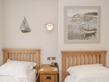 A bedroom with two single wooden beds and a wooden nightstand between them at Oak Cottage in Windermere
