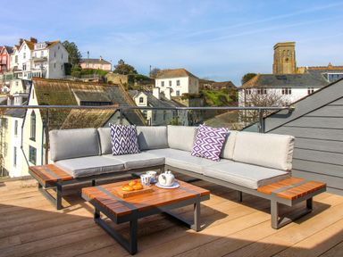 A sofa and coffee table with a view at The Penthouse in Salcombe