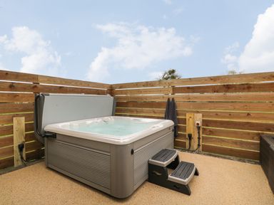 An outdoor hot tub with steps surrounded by wooden fencing at Lugg View in Cross Keys near Hereford