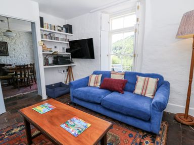 A living room with a blue sofa and a coffee table at Dolwylan Cottage in Cwmtydu near New Quay