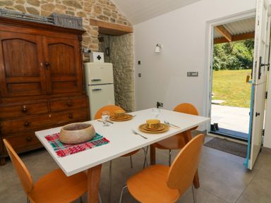 A dining room with a table set for meals at Dolwylan Barn Cwmtydu near New Quay