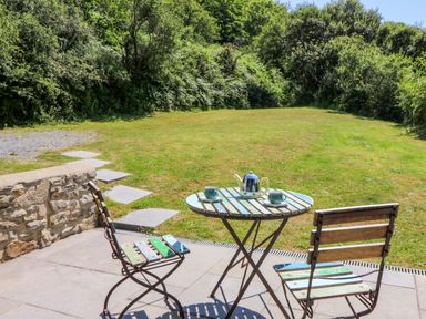 A table with chairs and teapot at Dolwylan Barn in Cwmtydu near New Quay