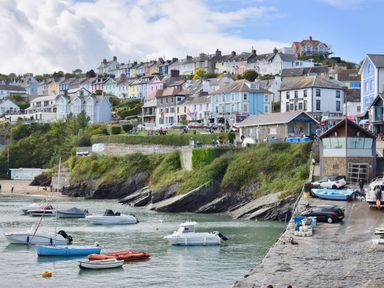 A coastal town with boats in the water and houses on a hill at Ty Ni in New Quay