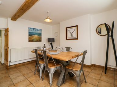 A dining room with a wooden table and six metal chairs at The Yellow House 13 King Street in Dawlish