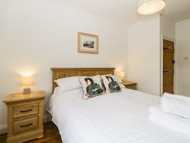 A bedroom with a double bed and wooden side tables with lamps at The Yellow House 13 King Street Dawlish