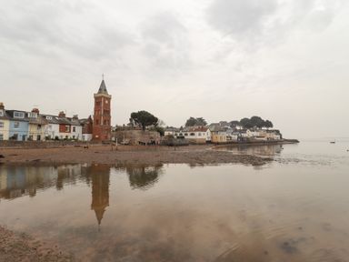 A coastal village with a clock tower and houses along the shore at 9 Harefield Cottages in Lympstone