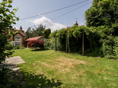 A garden with lawn trees shrubs and a house in the background at Oakapple Cottage Swan Green near Lyndhurst