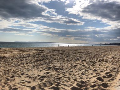 A sandy beach with the sea and a cloudy sky in the background at Oakapple Cottage in Swan Green near Lyndhurst