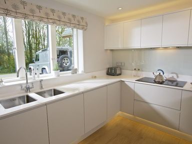 A modern kitchen with white cabinets a double sink a toaster and a kettle at 3 The Drive Hillfield Village Dartmouth