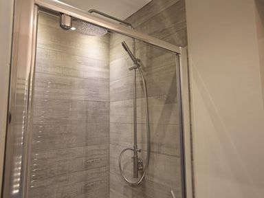 A shower area with a glass door and a rain showerhead at 3 The Drive Hillfield Village in Dartmouth