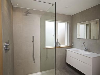 A bathroom with a walk-in shower a window a wall-mounted sink with a mirror above at 3 The Drive Hillfield Village Dartmouth