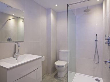 A bathroom with a sink a toilet and a shower area with glass partition at 3 The Drive Hillfield Village in Dartmouth