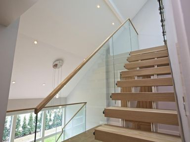A modern wooden staircase with glass railing inside a house at 3 The Drive Hillfield Village in Dartmouth